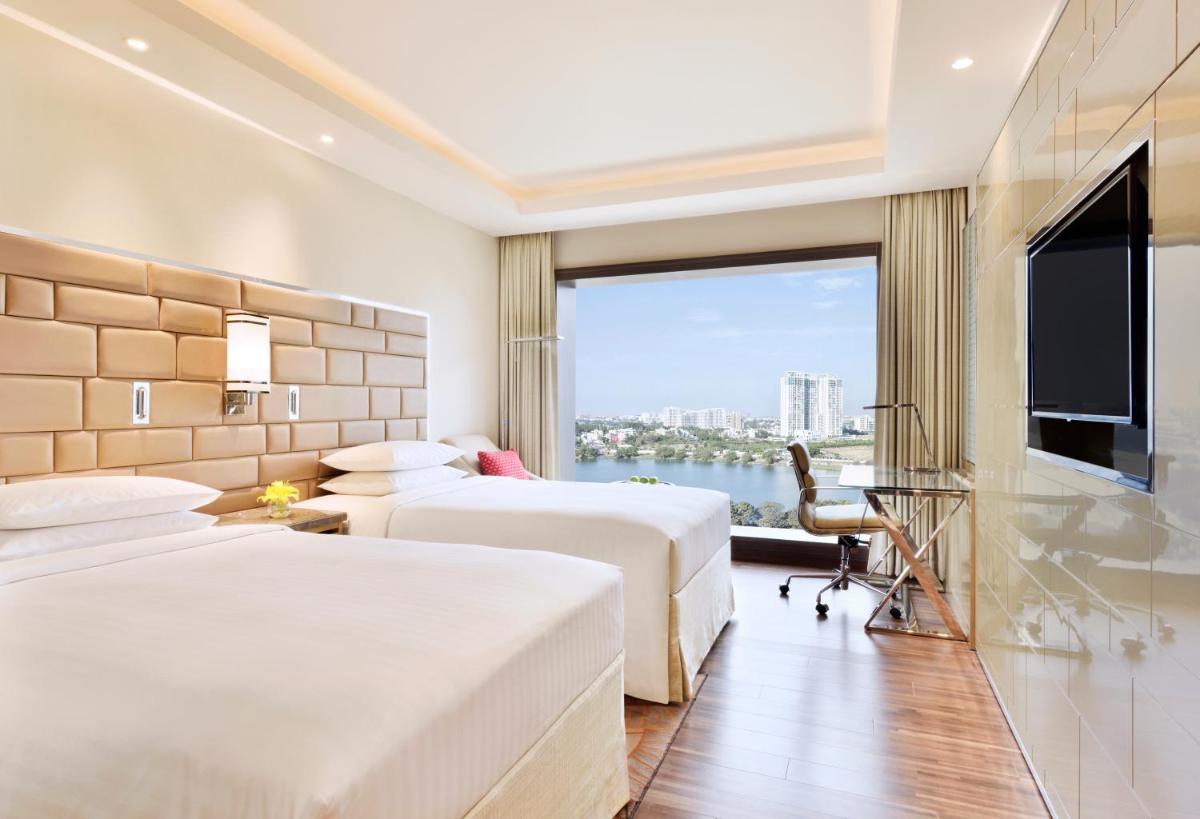 a hotel room with two beds and a large window at Courtyard by Marriott Bengaluru Hebbal in Bengaluru a hotel room with two beds and a large window at Courtyard by Marriott Bengaluru Hebbal in Bengaluru