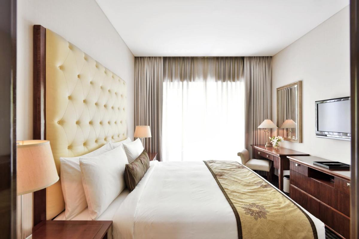 a hotel room with a large bed and a desk at Marriott Suites Pune in Pune +52 photos