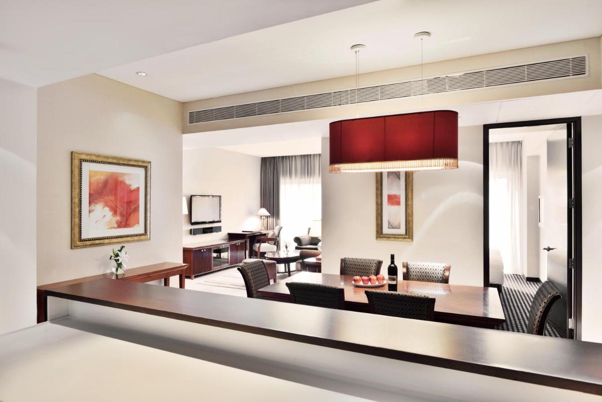 a living room with a table and chairs at Marriott Suites Pune in Pune