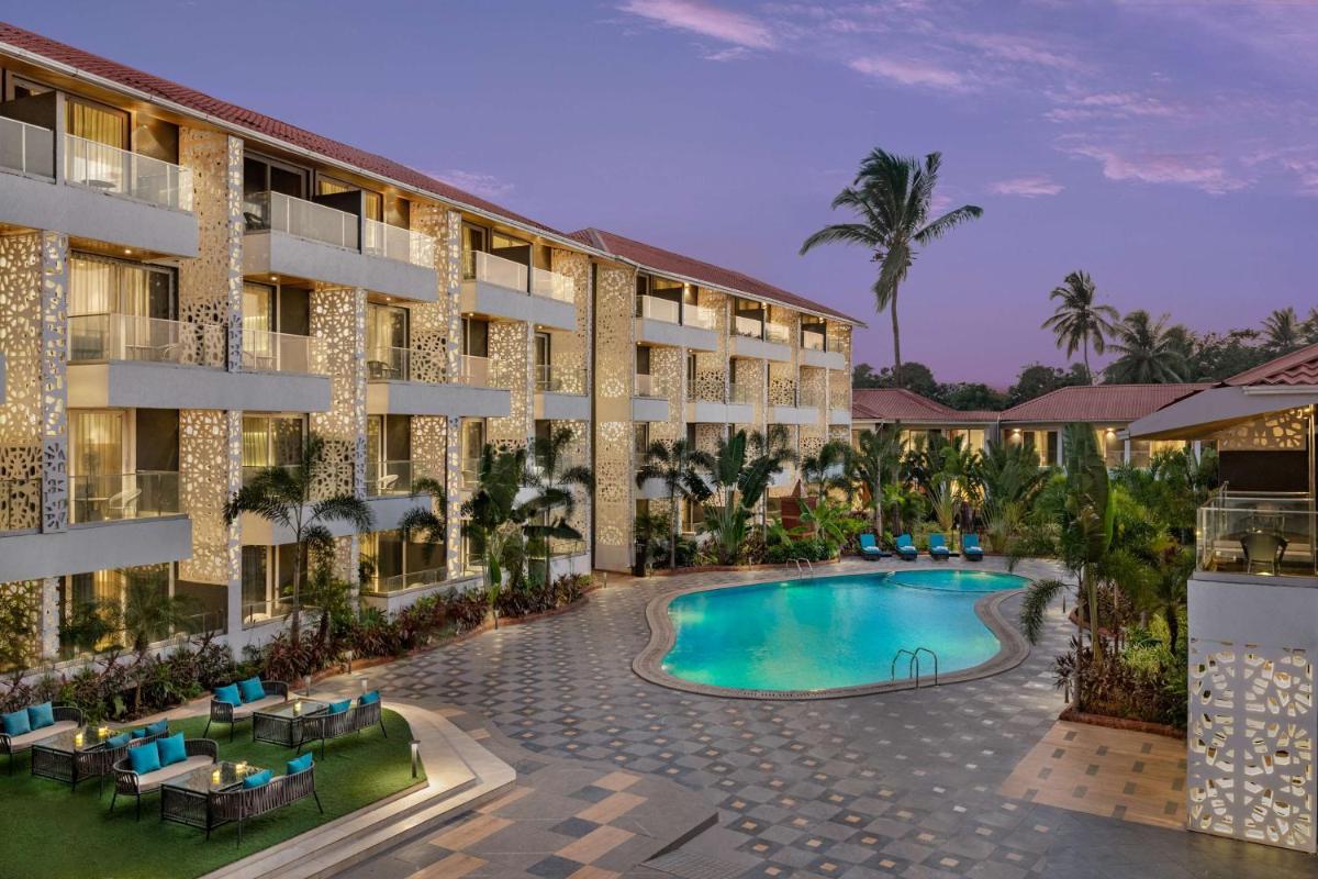 an exterior view of a hotel with a swimming pool at Hyatt Place Goa Candolim in Candolim an exterior view of a hotel with a swimming pool at Hyatt Place Goa Candolim in Candolim