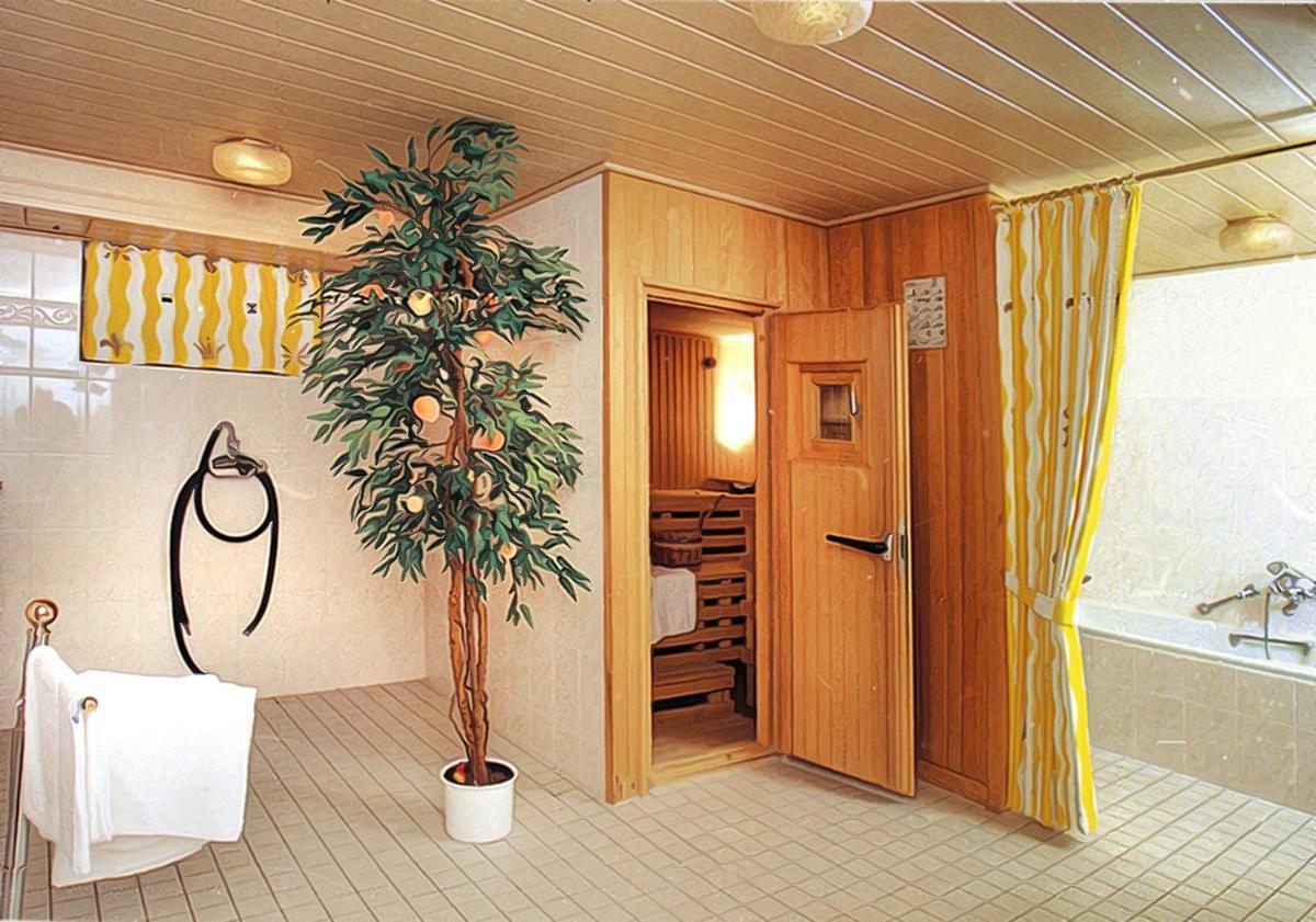 ein Badezimmer mit einer Topfpflanze und einer Badewanne in der Unterkunft Wellness und Romantik Hotel Helmboldt in Bad Sachsa