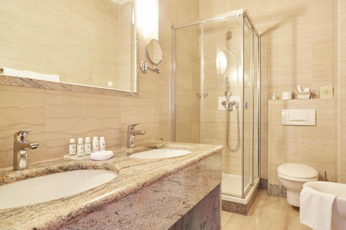 Un baño con dos lavabos y una ducha. en Grand Hotel Palladium Santa Eulalia del Río, en Santa Eulària des Riu