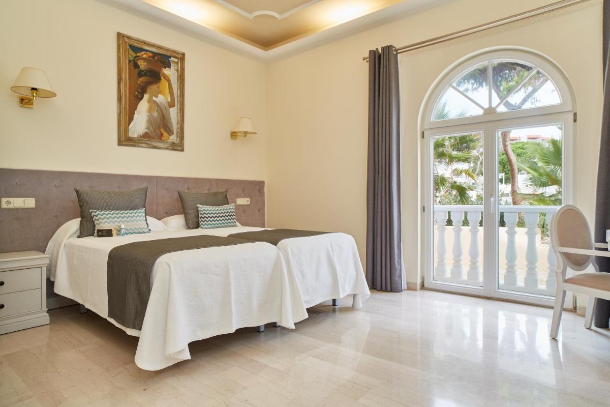 Un dormitorio con una cama y una ventana grande. en Grand Hotel Palladium Santa Eulalia del Río, en Santa Eulària des Riu