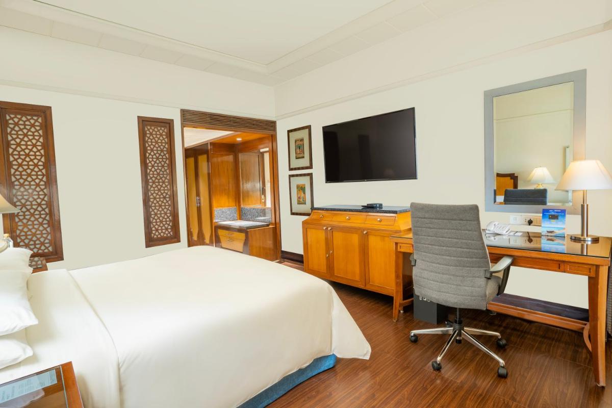 a hotel room with a bed and a desk and a computer at Hyderabad Marriott Hotel & Convention Centre in Hyderabad