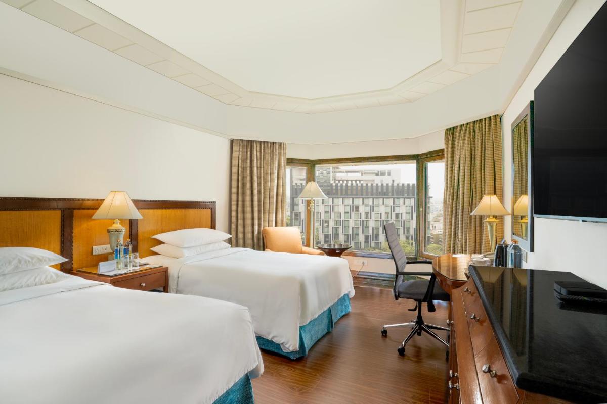 a hotel room with two beds and a flat screen tv at Hyderabad Marriott Hotel & Convention Centre in Hyderabad
