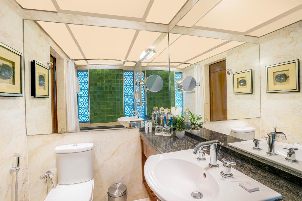 a bathroom with a sink and a toilet and a mirror at Hyderabad Marriott Hotel & Convention Centre in Hyderabad
