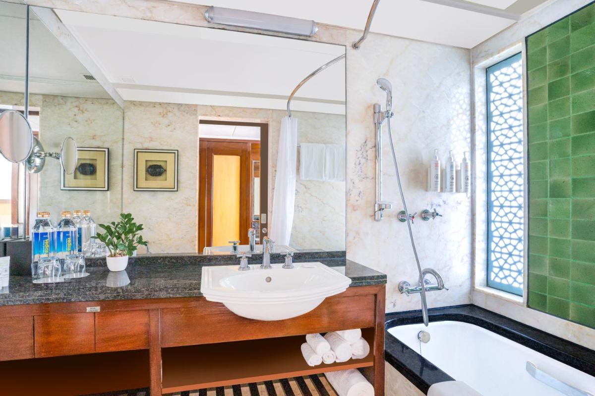 a bathroom with a sink and a tub and a mirror at Hyderabad Marriott Hotel & Convention Centre in Hyderabad