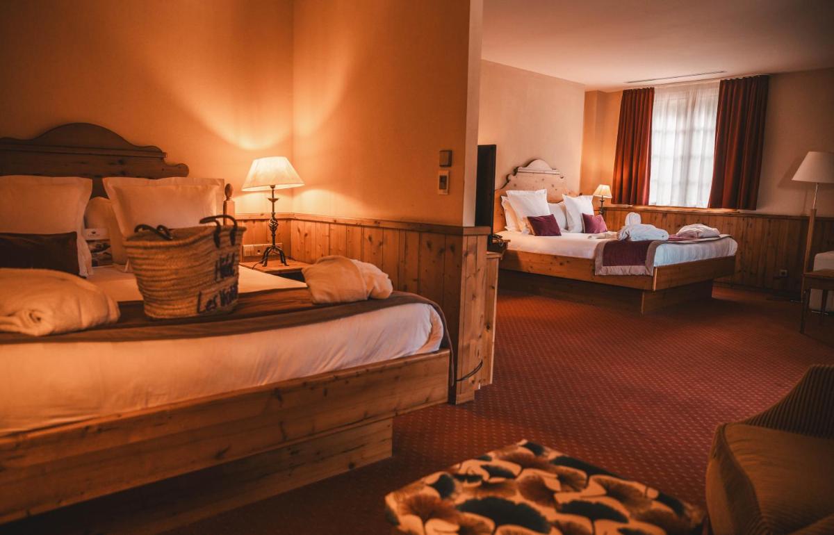 Un ou plusieurs lits dans un hébergement de l'établissement Les Violettes Hotel & Spa