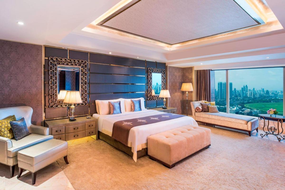 a bedroom with a bed and a chair and a window at The St. Regis Mumbai in Mumbai