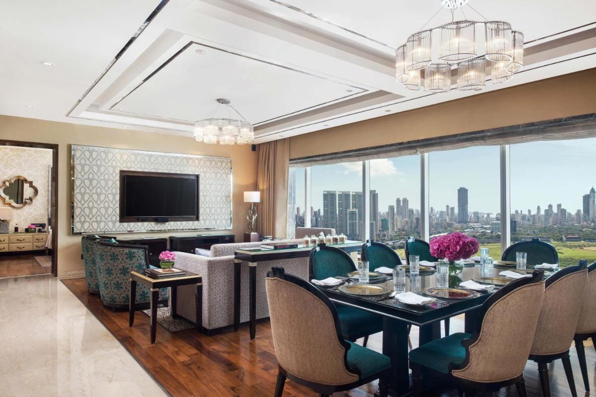 a dining room with a table and chairs and a television at The St. Regis Mumbai in Mumbai