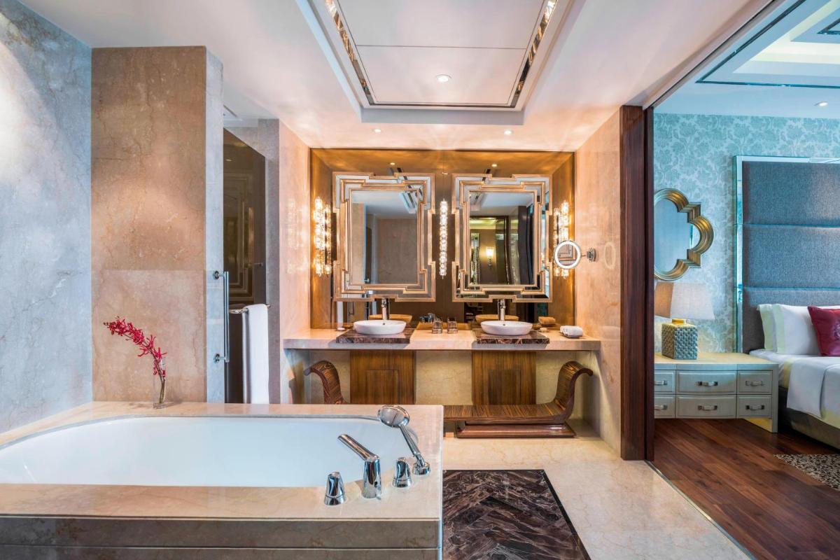 a bathroom with a bath tub and a bedroom at The St. Regis Mumbai in Mumbai
