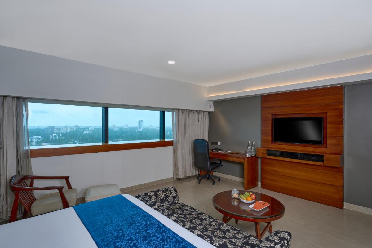 a hotel room with a bed and a tv at The Raviz Calicut in Kozhikode