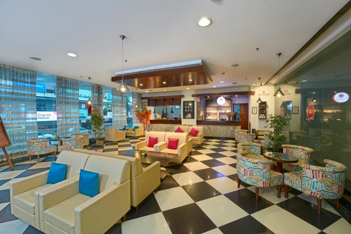 a lobby with couches and chairs on a checkered floor at The Raviz Calicut in Kozhikode