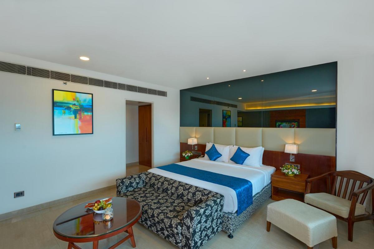 a hotel room with a bed and a table at The Raviz Calicut in Kozhikode