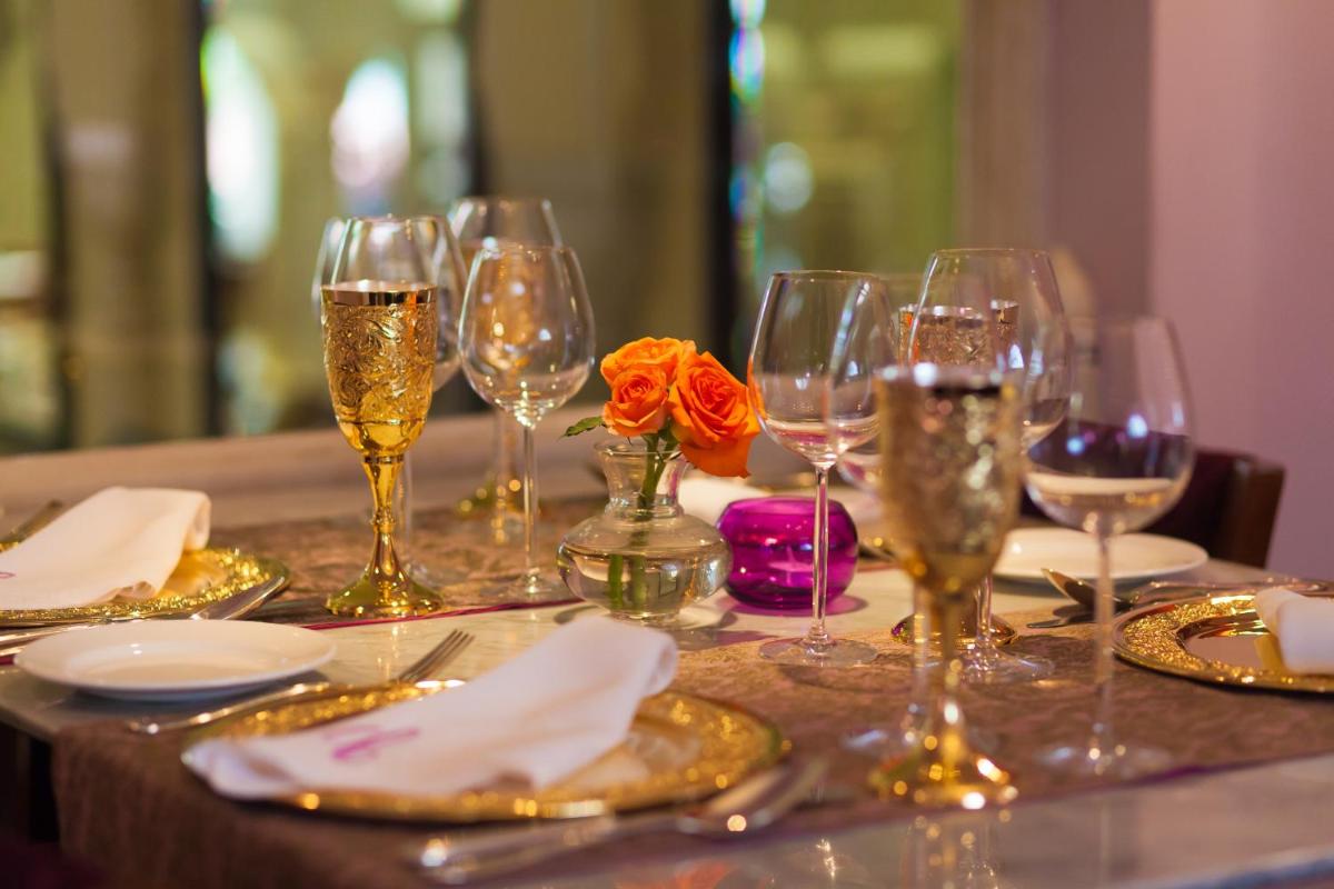 a table with wine glasses and a flower on it at Jai Mahal Palace in Jaipur