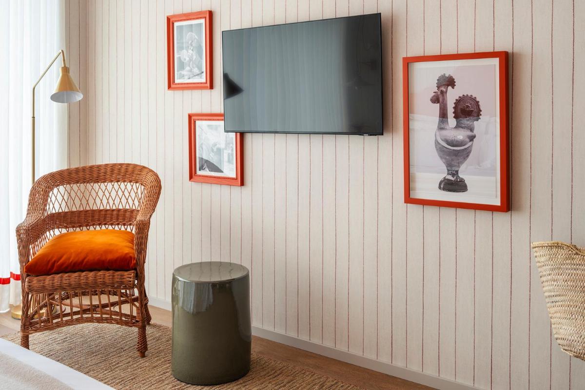 um quarto com uma televisão numa parede com uma cadeira em Solar de Vila Meã em Barcelos