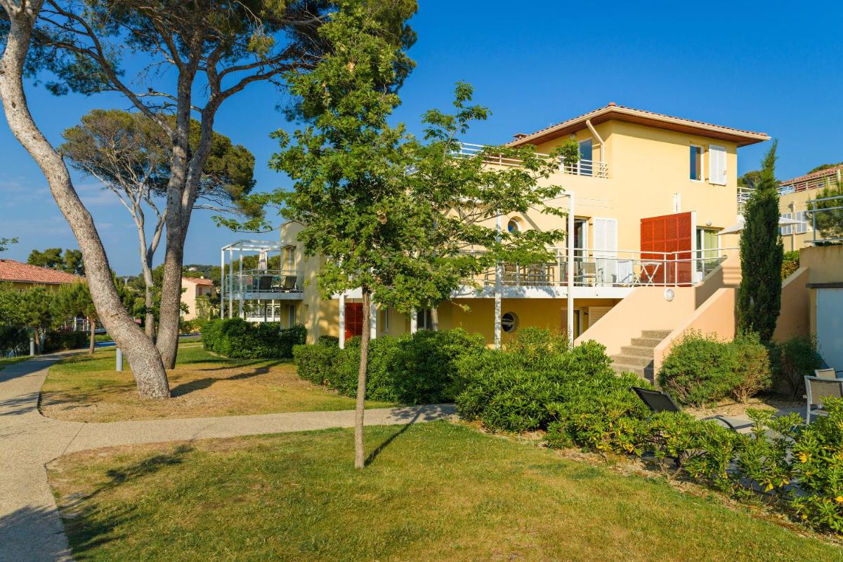 une maison avec un arbre dans la cour dans l'établissement Lagrange Vacances Les Terrasses des Embiez, à Six-Fours-les-Plages