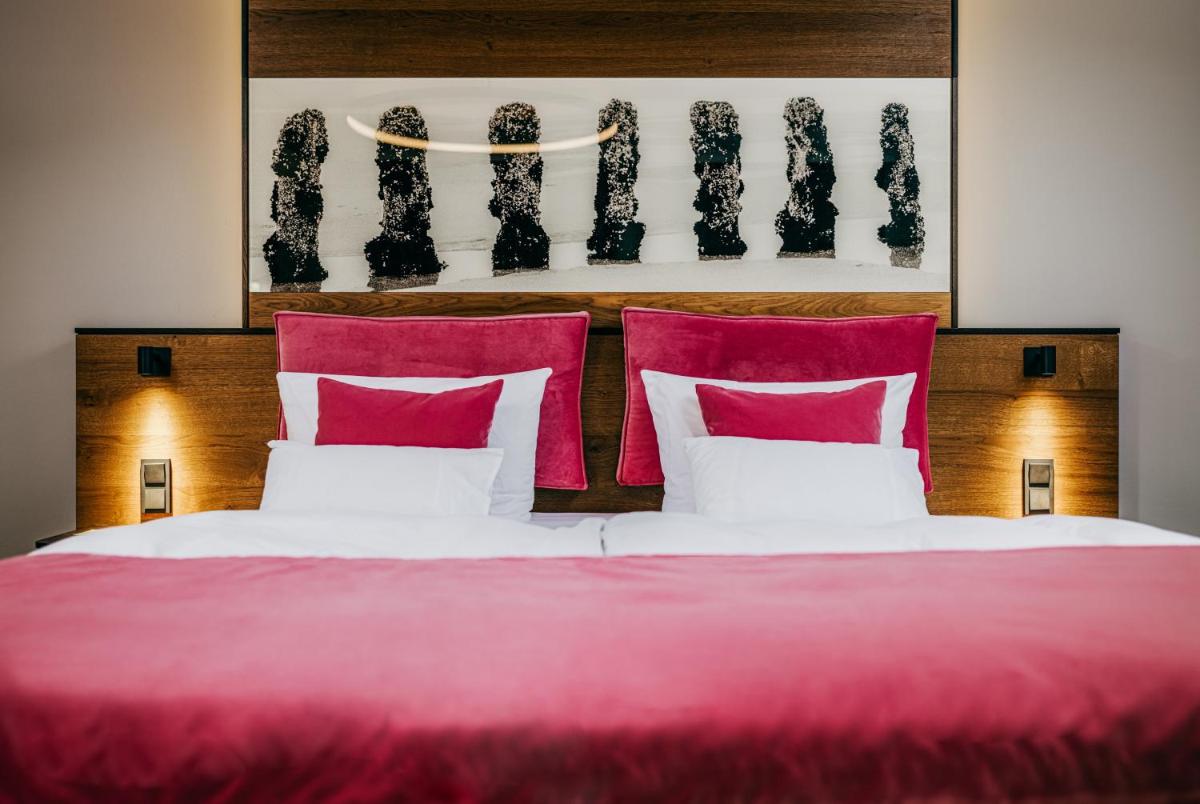 Ein Bett oder Betten in einem Zimmer der Unterkunft Relais & Châteaux Landhaus Stricker