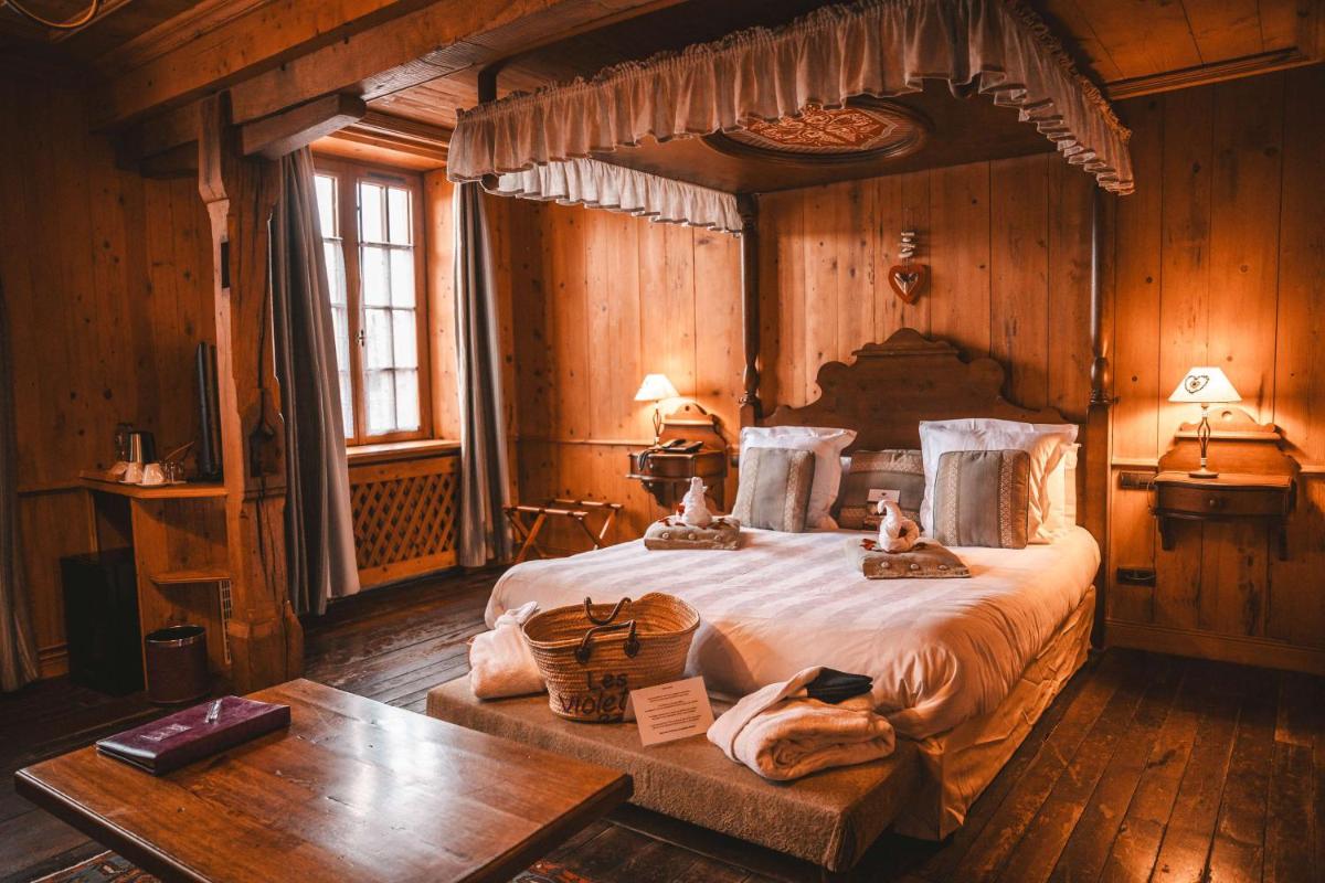 une chambre avec un grand lit dans une cabine dans l'établissement Les Violettes Hotel & Spa, à Jungholtz