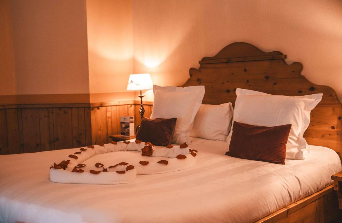 Un ou plusieurs lits dans un hébergement de l'établissement Les Violettes Hotel & Spa