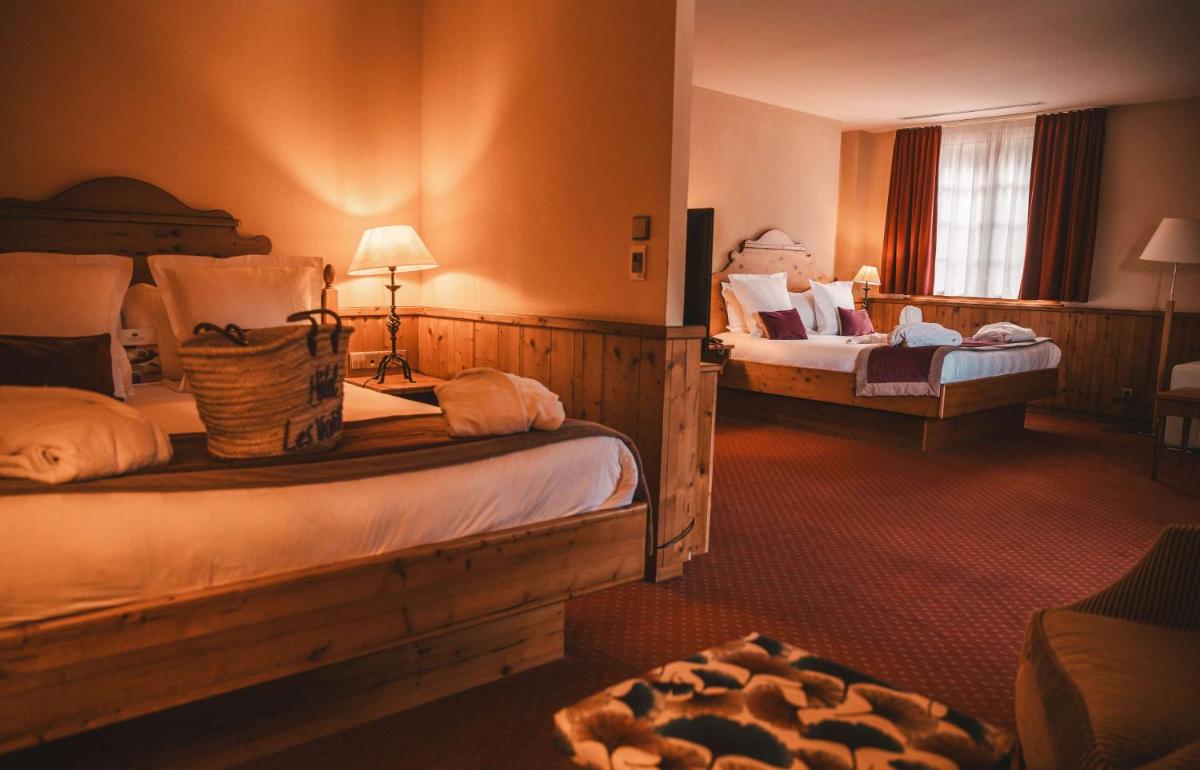 Un ou plusieurs lits dans un hébergement de l'établissement Les Violettes Hotel & Spa