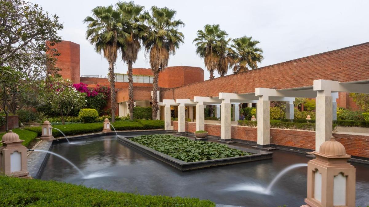 a courtyard with a fountain and palm trees at ITC Mughal, A Luxury Collection Resort & Spa, Agra in Agra