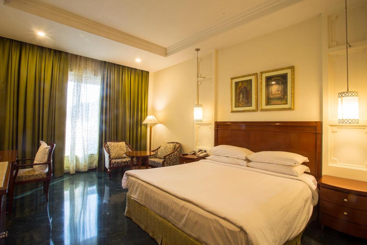 a hotel room with a bed and a table and chairs at ITC Rajputana, a Luxury Collection Hotel, Jaipur in Jaipur