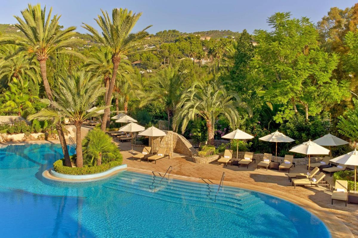 un complejo con piscina con sombrillas, sillas y árboles en Sheraton Mallorca Arabella Golf Hotel, en Palma de Mallorca