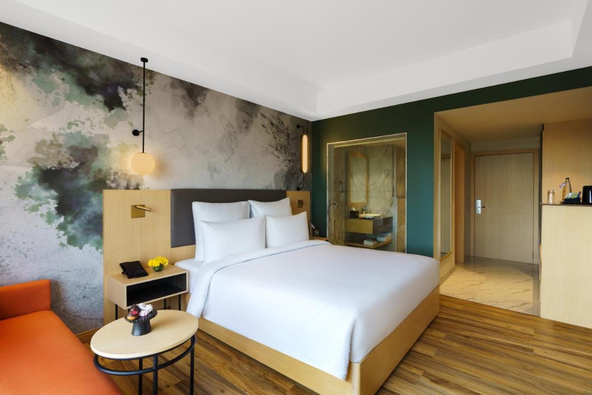 a hotel room with a bed and a couch at Novotel Jaipur Convention Centre in Jaipur