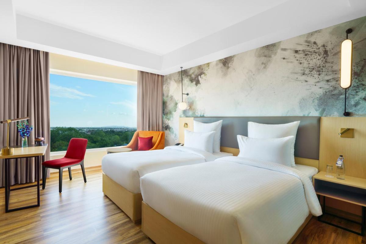 two beds in a hotel room at Novotel Jaipur Convention Centre in Jaipur