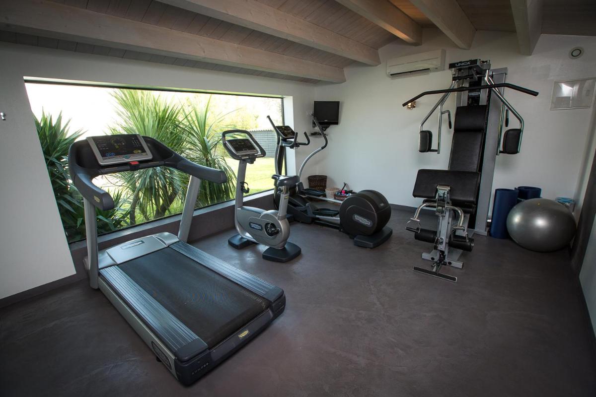 - une salle de sport avec un tapis de course et 2 vélos d'exercice dans l'établissement Le Clos Saint-Martin Hôtel & Spa, à Saint-Martin-de-Ré