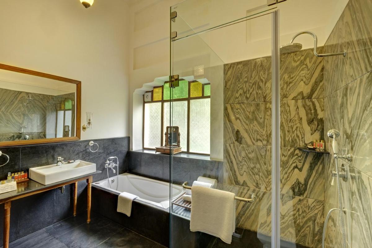 a bathroom with a tub and a sink and a shower at Saraca Hotel Lucknow in Lucknow