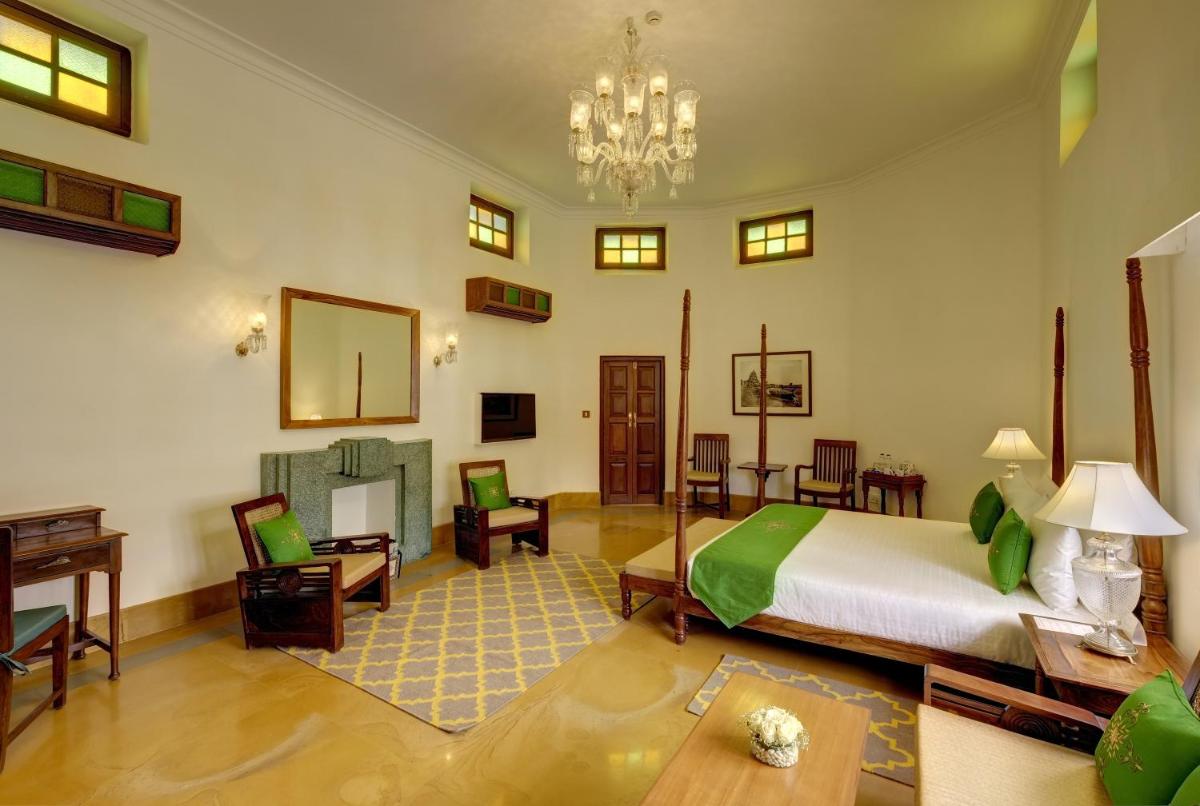 a bedroom with a bed and a living room at Saraca Hotel Lucknow in Lucknow
