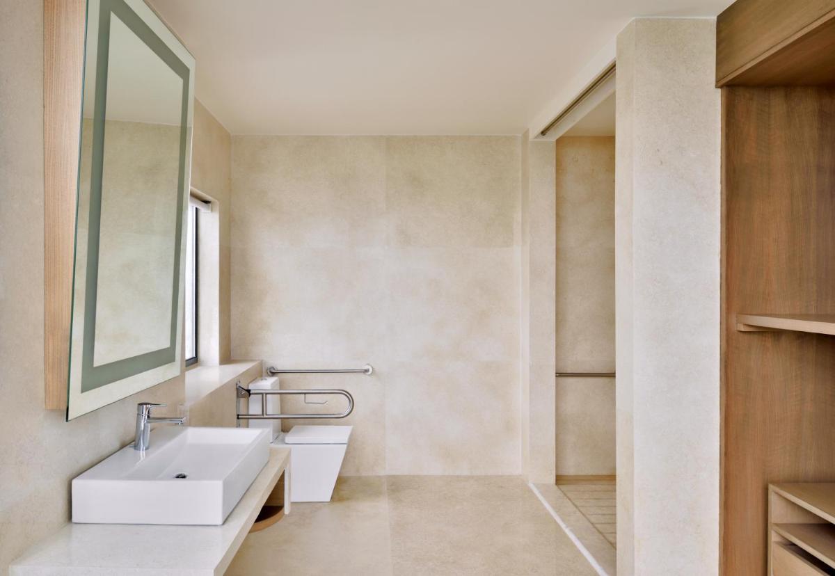 a bathroom with a sink and a mirror at The Westin Kolkata Rajarhat in Kolkata a bathroom with a sink and a mirror at The Westin Kolkata Rajarhat in Kolkata