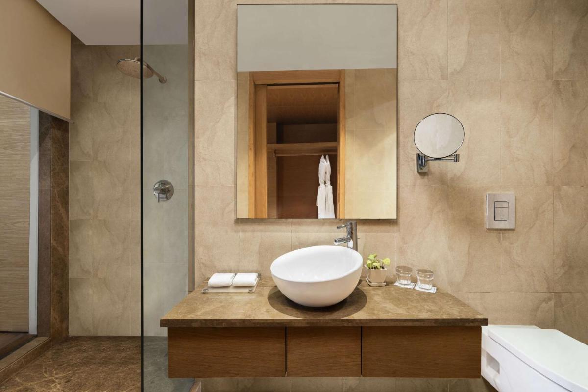 a bathroom with a sink and a mirror at Radisson Blu Hotel New Delhi Dwarka in New Delhi a bathroom with a sink and a mirror at Radisson Blu Hotel New Delhi Dwarka in New Delhi