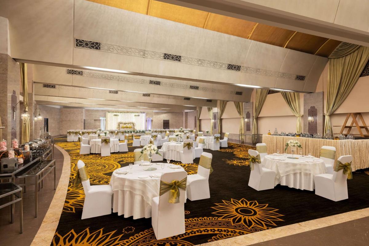 a banquet hall with white tables and chairs at Radisson Blu Hotel New Delhi Dwarka in New Delhi a banquet hall with white tables and chairs at Radisson Blu Hotel New Delhi Dwarka in New Delhi