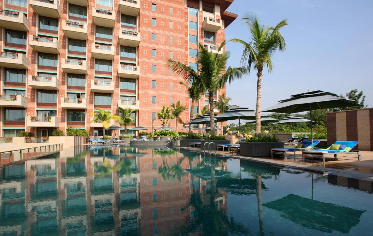 a swimming pool in front of a large building at ITC Gardenia, a Luxury Collection Hotel, Bengaluru in Bengaluru a swimming pool in front of a large building at ITC Gardenia, a Luxury Collection Hotel, Bengaluru in Bengaluru