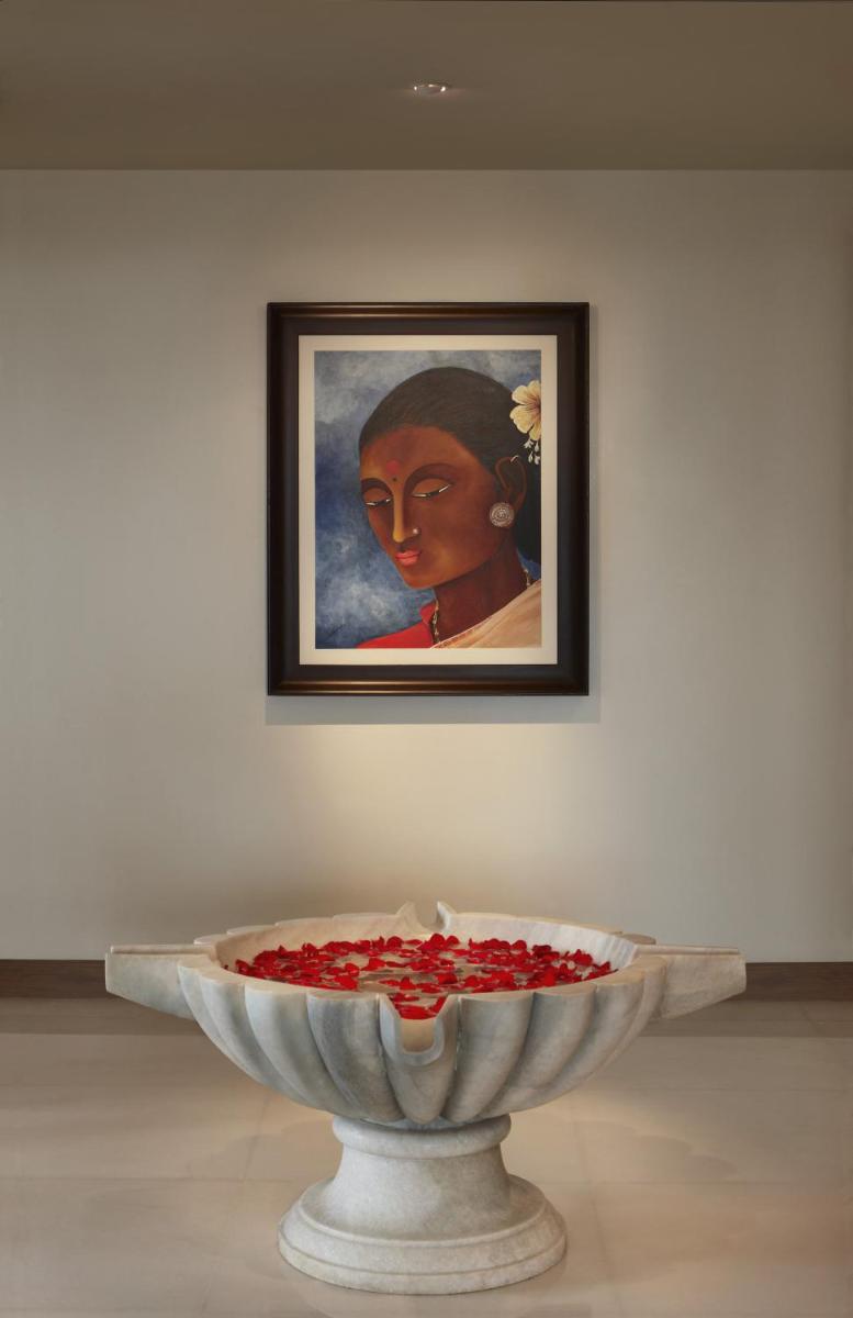 a art exhibit with a bowl of roses in front of a painting at ITC Gardenia, a Luxury Collection Hotel, Bengaluru in Bengaluru a art exhibit with a bowl of roses in front of a painting at ITC Gardenia, a Luxury Collection Hotel, Bengaluru in Bengaluru