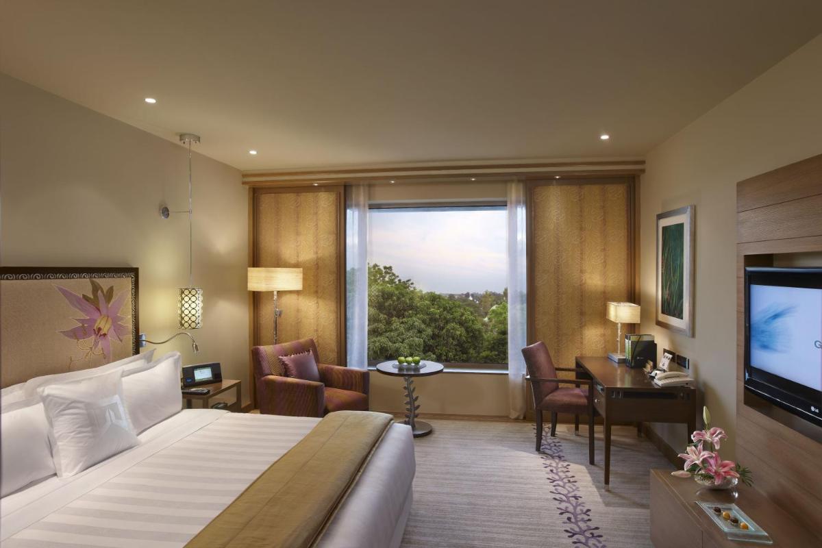 a hotel room with a bed and a large window at ITC Gardenia, a Luxury Collection Hotel, Bengaluru in Bengaluru a hotel room with a bed and a large window at ITC Gardenia, a Luxury Collection Hotel, Bengaluru in Bengaluru
