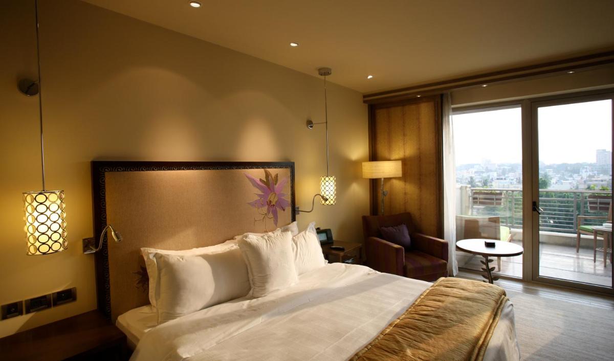 a hotel room with a bed and a balcony at ITC Gardenia, a Luxury Collection Hotel, Bengaluru in Bengaluru a hotel room with a bed and a balcony at ITC Gardenia, a Luxury Collection Hotel, Bengaluru in Bengaluru