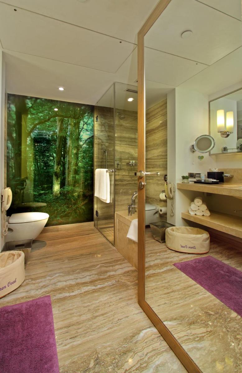 a bathroom with a glass shower and a toilet at ITC Gardenia, a Luxury Collection Hotel, Bengaluru in Bengaluru a bathroom with a glass shower and a toilet at ITC Gardenia, a Luxury Collection Hotel, Bengaluru in Bengaluru