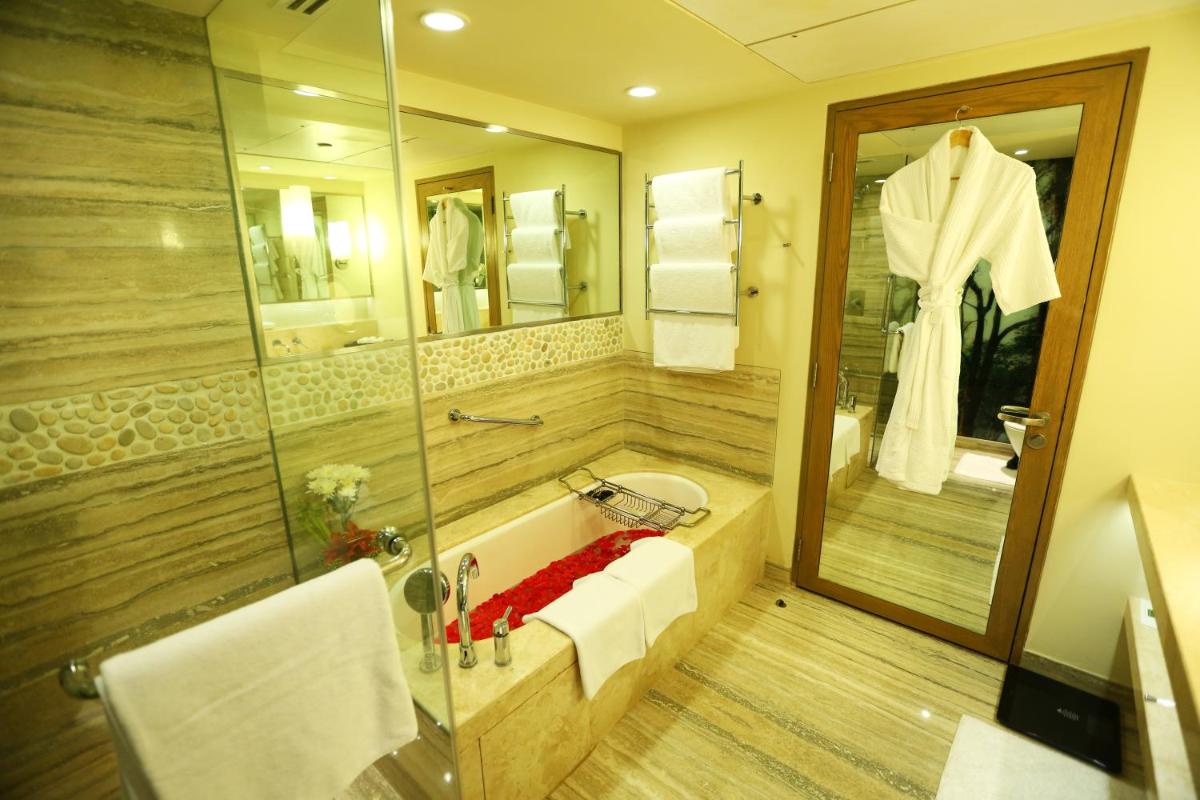 a bathroom with a tub and a sink and a shower at ITC Gardenia, a Luxury Collection Hotel, Bengaluru in Bengaluru a bathroom with a tub and a sink and a shower at ITC Gardenia, a Luxury Collection Hotel, Bengaluru in Bengaluru