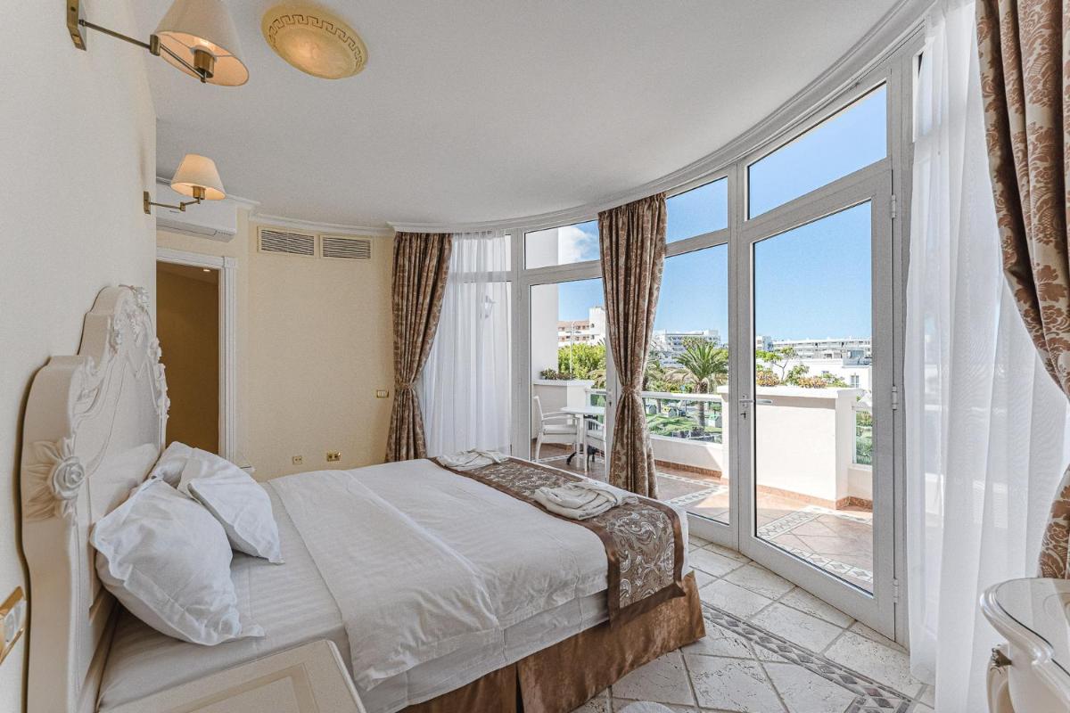 Un dormitorio con una cama y una ventana grande. en Flamingo Suites Boutique Hotel, en Adeje 150 fotos más