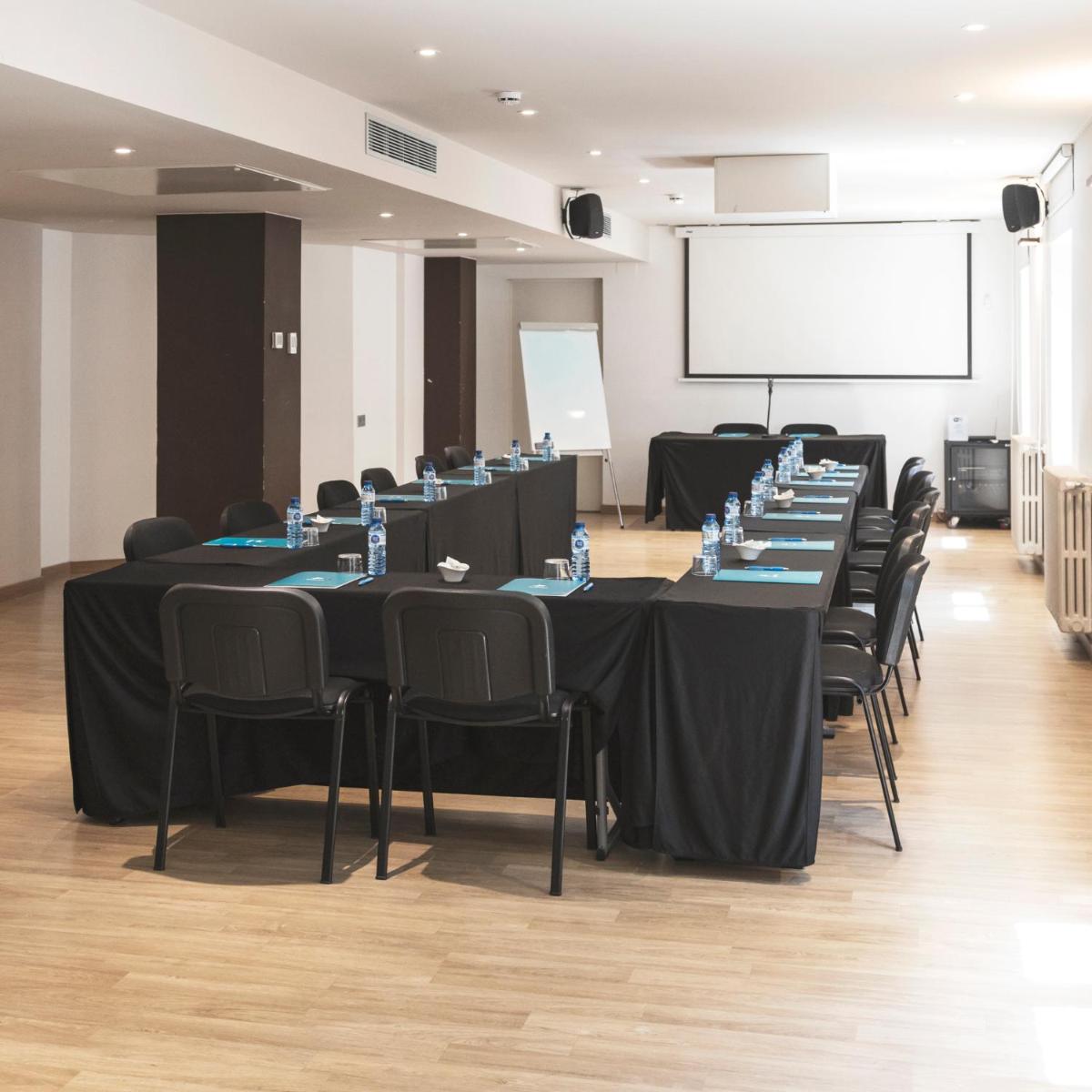 Una sala de conferencias con mesas, sillas y una pantalla. en Hotel & Spa Real Villa Anayet, en Canfranc-Estación 69 fotos más