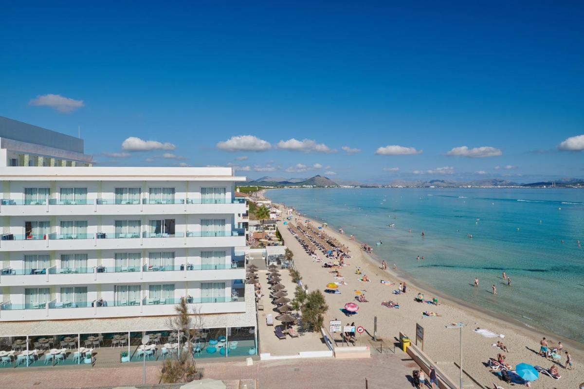 una playa con un gran edificio y gente en él en The Sea Hotel by Grupotel - Adults Only, en Can Picafort