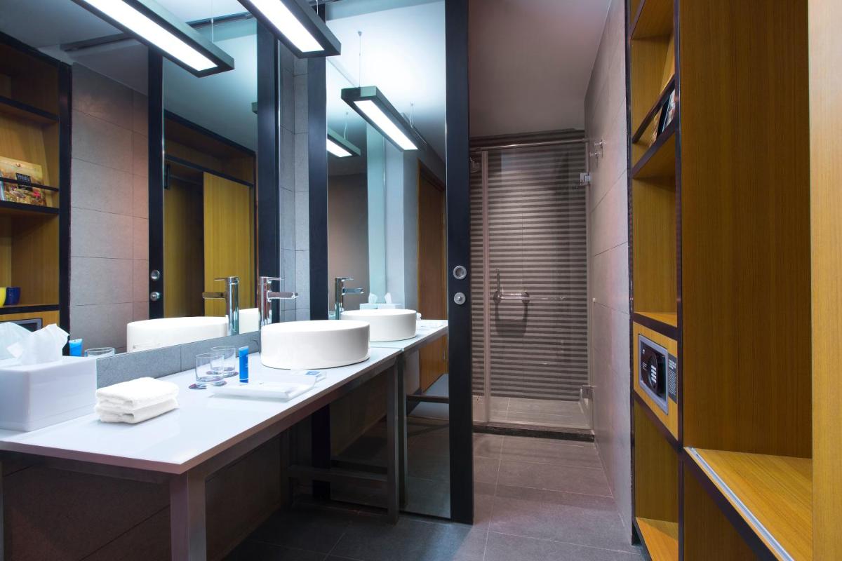 a bathroom with three sinks and a large mirror at Aloft Bengaluru Outer Ring Road in Bengaluru