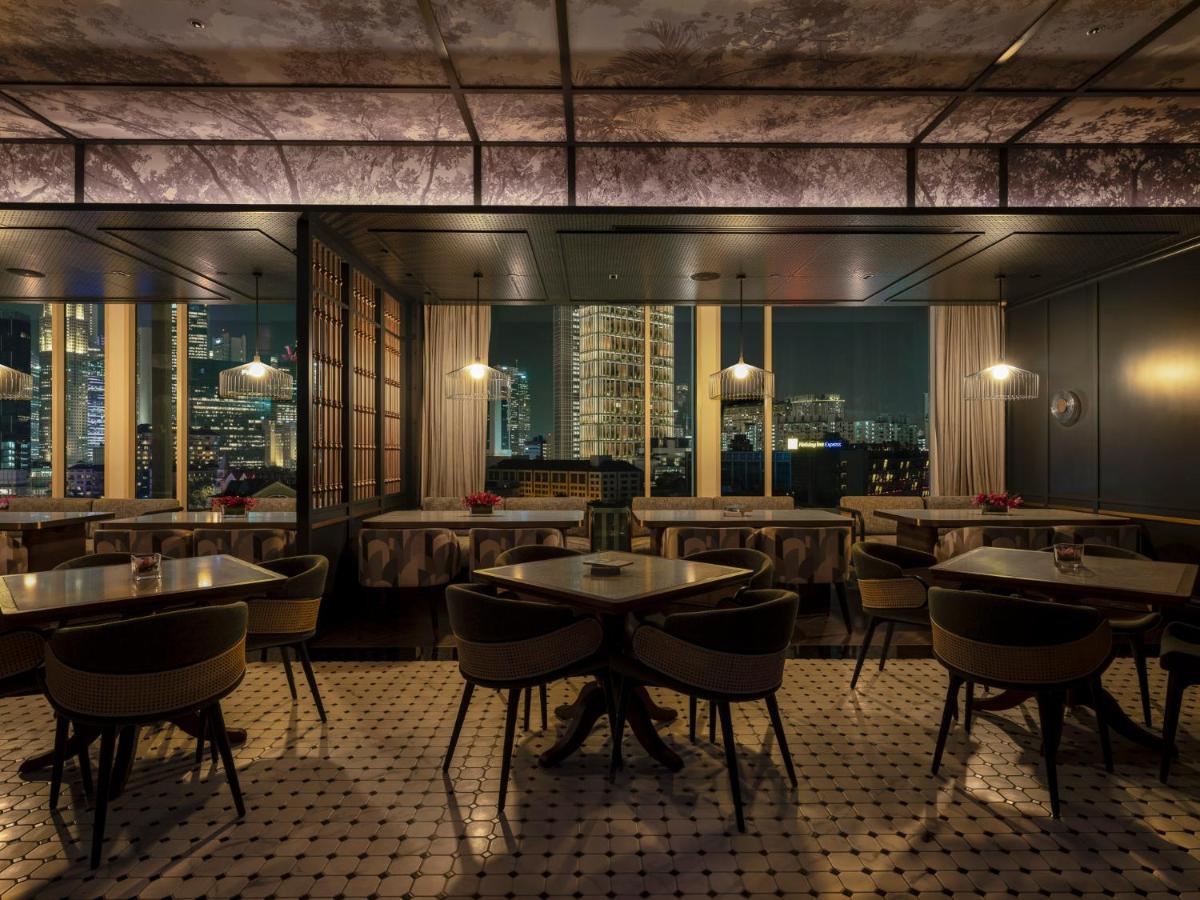 a restaurant with tables and chairs and a view of a city at The Robertson House by The Crest Collection in Singapore