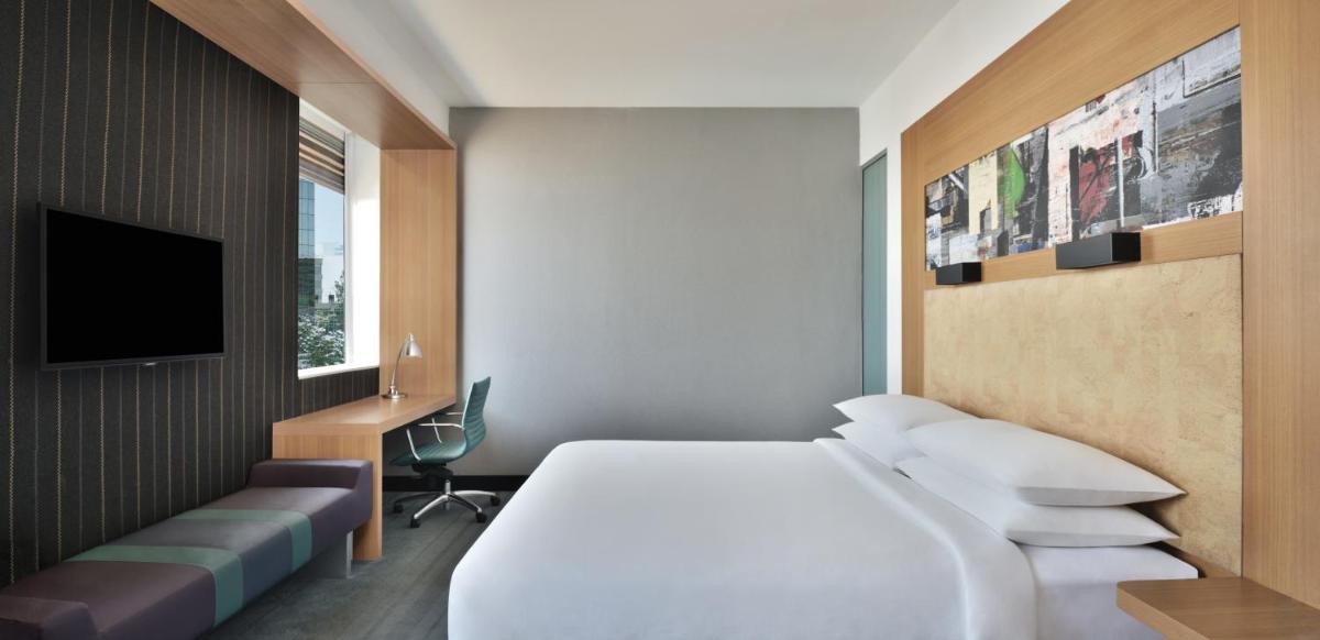 a hotel room with a bed and a tv at Aloft Bengaluru Outer Ring Road in Bengaluru