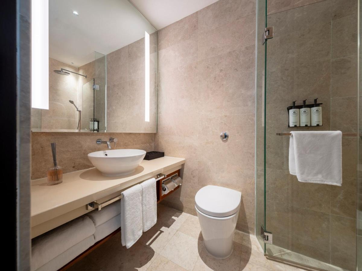 a bathroom with a sink and a toilet and a shower at The Robertson House by The Crest Collection in Singapore a bathroom with a sink and a toilet and a shower at The Robertson House by The Crest Collection in Singapore