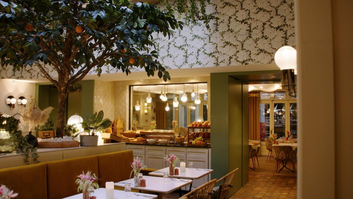 un restaurant avec des tables, des chaises et un comptoir dans l'établissement Royal Madeleine Hotel & Spa, à Paris